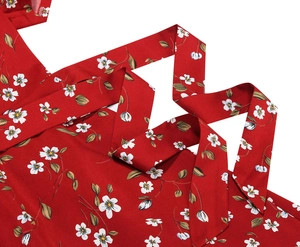 Detail of red floral print dress with white daisy pattern and neat stitching detail