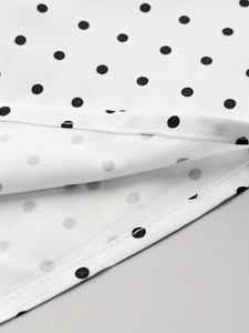 Détail macro du tissu à pois blancs avec une couture d'ourlet de qualité