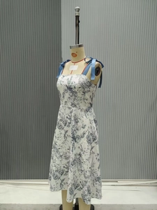 Dettaglio dell'abito floreale a trapezio con spalline in nastro blu e stampa rose
