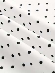 Gros plan détaillé sur le tissu blanc à pois noirs avec texture tissée raffinée