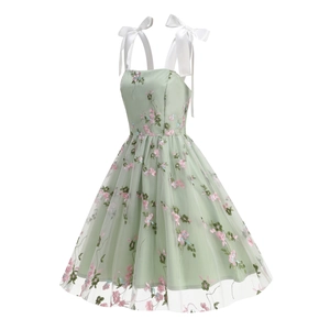 Detailed embroidery of pink and blue flowers on light green mesh dress fabric