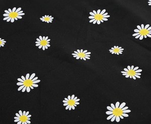 Close-up detail of white daisy floral embroidery on black mesh fabric high waist skirt