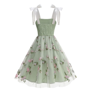 Detailed view of green mesh dress featuring exquisite pink floral embroidery and leaf patterns