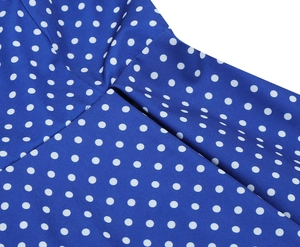 Gros plan d'une robe bleue à pois montrant les coutures de qualité et le tissu tissé