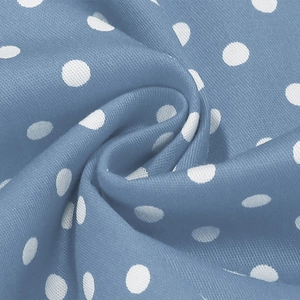 Détail du tissu bleu clair à pois blancs montrant la texture textile et le motif