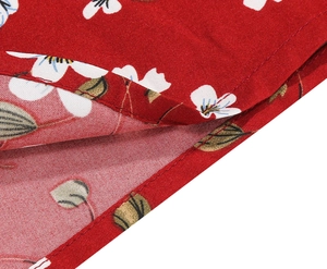 Macro detail of red floral dress fabric showing high-quality stitching and petal print