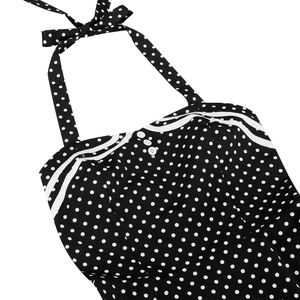 Detail of retro polka dot halter dress featuring bow tie and wavy lace trim accents