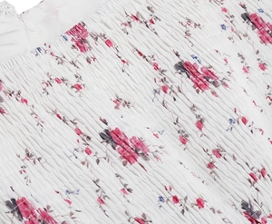 Detail of floral smocked fabric with white lace trim and elastic embroidery texture