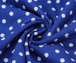 Vue macro détaillée du tissu bleu à pois blancs avec un tombé fluide et une texture douce