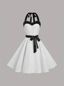 Détail d'une robe licou à pois vintage avec décolleté en cœur et nœud noir à la taille