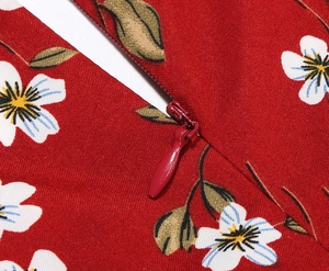 Detailed close-up of a high-quality invisible zipper on a red floral vintage dress