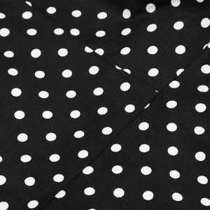 Close-up of high-quality black cotton fabric with classic white polka dot pattern detail