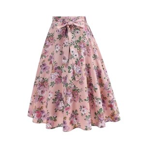 Detail of floral A-line skirt featuring pink petal patterns and a matching waist tie bow