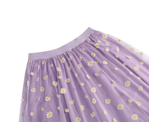 Detailed view of elastic waistband and white daisy prints on light purple mesh midi skirt