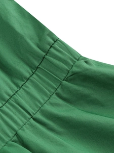 Dettaglio del tessuto twill verde con pieghe elasticizzate e cuciture parallele