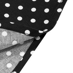 Detailed macro view showing the high-quality stitching on black polka dot cotton fabric