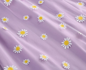 Close-up of purple mesh fabric with delicate white and yellow daisy floral embroidery
