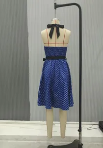 Détail d'une robe vintage bleue à pois avec col licou et nœud papillon noir au dos