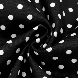 Macro detail of soft cotton fabric with classic white polka dots on a black base