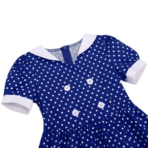 Detail of blue polka dot girls dress showing Peter Pan collar and decorative buttons