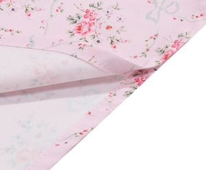 Detail shot of pink floral dress fabric showing high-quality stitching and sewing craft
