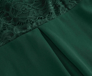Detail of dark green lace floral embroidery and pleated texture on vintage V-neck dress