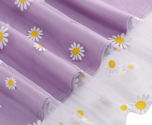 Detail of purple daisy print mesh fabric with delicate stitching and layered texture