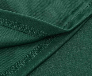 Detailed macro view of high-quality overlock stitching on dark green vintage dress fabric
