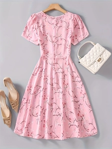 Flat lay of pink floral A-line summer dress with white handbag and beige pointed heels