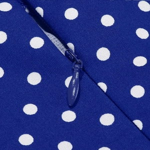 Macro detail of royal blue polka dot fabric featuring a seamless invisible zipper closure