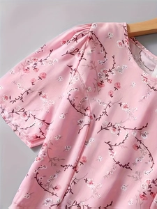Detail of pink floral print top showing round neck, puff sleeves and pleated texture