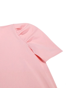 Abito estivo rosa in maglia con eleganti maniche a sbuffo e dettagli di pieghe sulla spalla