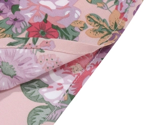 Close-up of pink floral woven fabric showing fine stitching and soft summer print