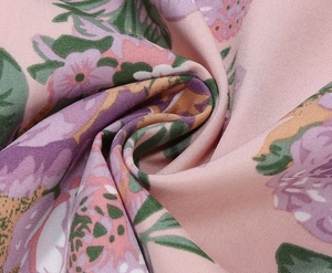 Detailed macro view of pink floral twill fabric with purple flowers and strawberry pattern