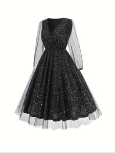 Detail of V-neck dress with sheer mesh sleeves and silver star patterns on black fabric