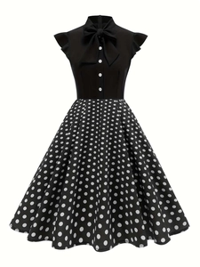 Detail of vintage 1950s dress featuring a bow neckline and polka dot high waist skirt