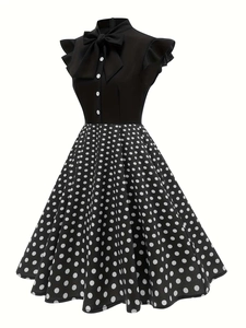 Detail of a vintage 1950s Hepburn style dress with polka dot skirt and bow neckline