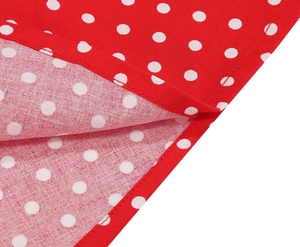 Gros plan sur le tissu à pois rouges et blancs avec ourlet détaillé à double couture