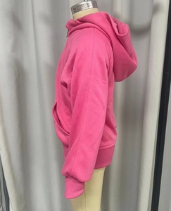 Détail du tissu lourd et des poignets côtelés sur le sweat à capuche rose enfant