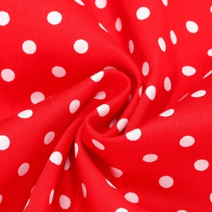 Macro shot of red and white polka dot cotton fabric showing detailed soft pleated texture