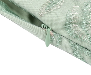 Detail of mint green fabric with white embroidery and matching invisible zipper