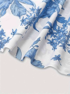Gros plan sur tissu blanc avec imprimé floral bleu et texture fluide élégante
