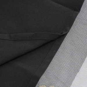 Dettaglio ravvicinato del tessuto nero dell'abito con cuciture e maglia sottile
