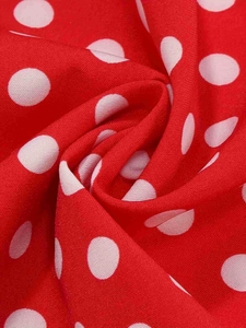 Detailed macro view of retro red fabric with white polka dots and spiral texture