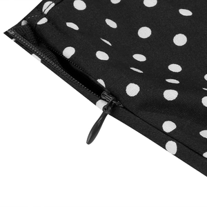 Détail de la fermeture éclair invisible et motif à pois blancs sur robe noire rétro