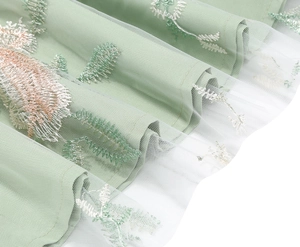 Macro detail of multi-color floral embroidery on vintage light green mesh evening dress