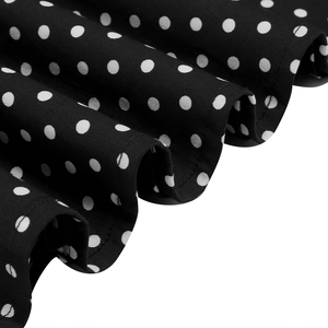 Gros plan sur tissu noir à pois blancs montrant la texture plissée et les coutures