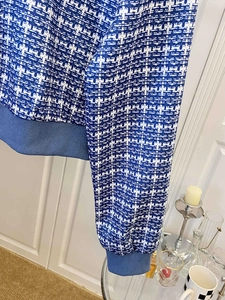 Detailed close-up of blue and white tweed pattern jacket with ribbed elastic cuffs