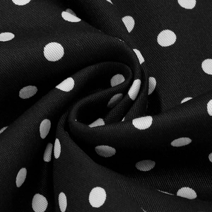 Détail de près du tissu rétro noir avec motifs à pois blancs et texture lisse