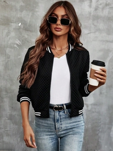 Detail of black quilted baseball jacket featuring striped ribbed cuffs and collar